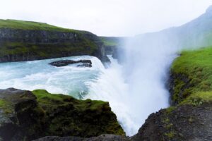 waterfalls in the middle of green grass covered mountain